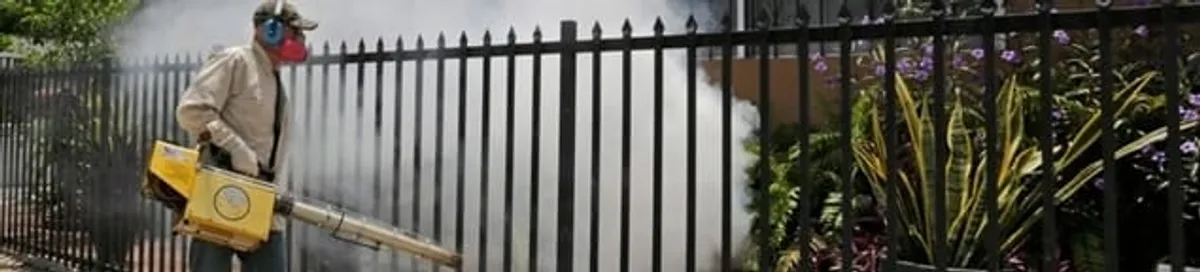 Mosquito control technician fogging a yard perimeter for mosquito reduction in Jacksonville, FL